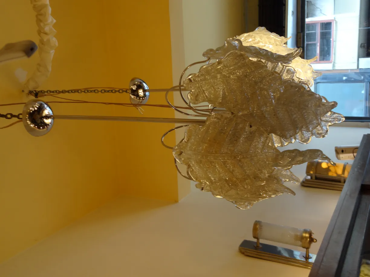 2 lustres anciens avec un design de feuilles, dans une ambiance claire.