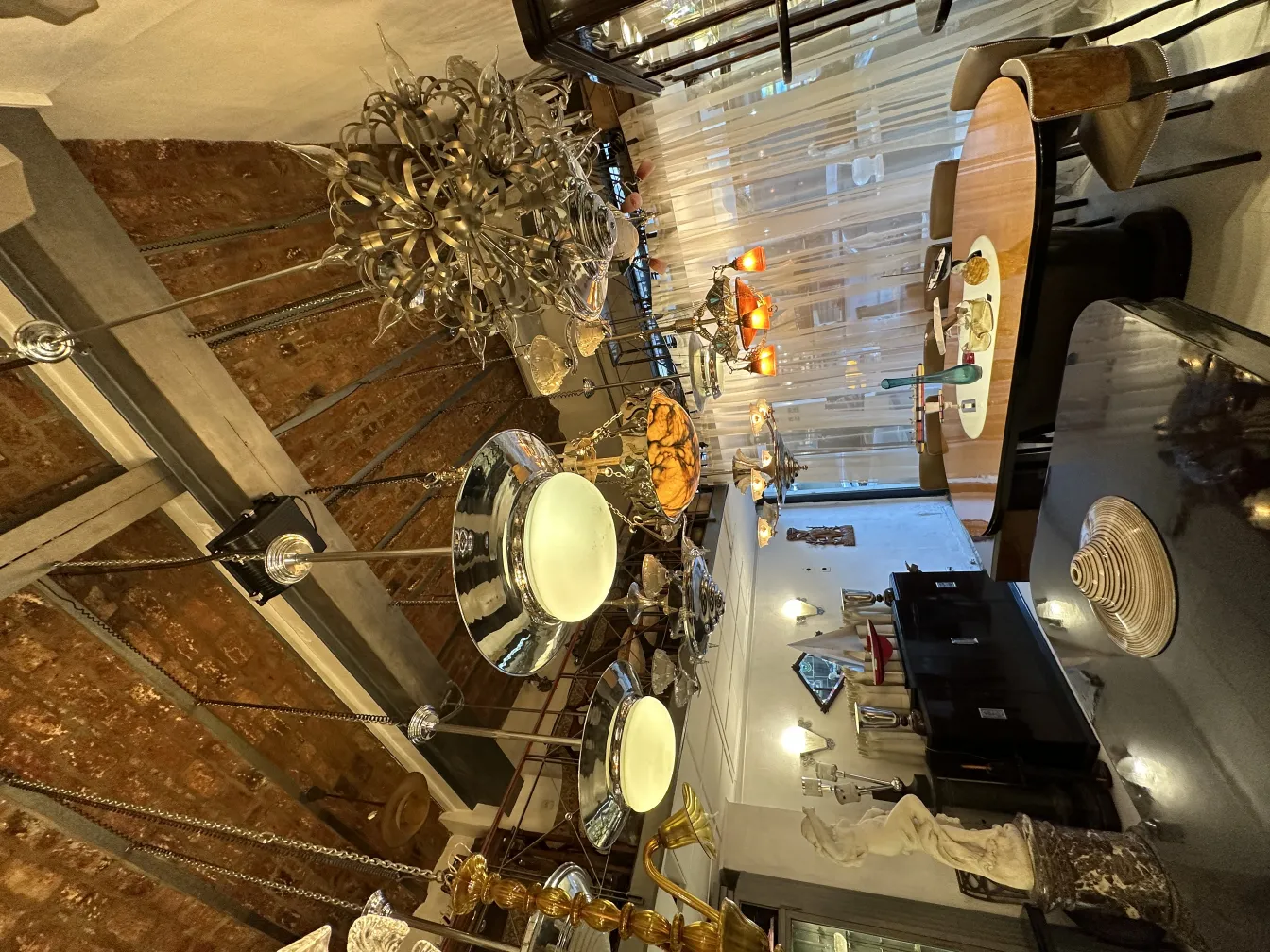 2 antique decorative hanging lamps in a cozy setting with a table and chairs