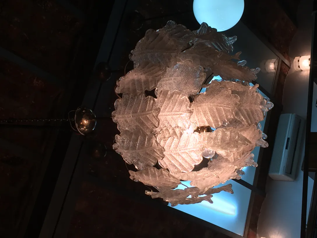 Deux lustres anciens avec des formes décoratives suspendus à un plafond sombre.