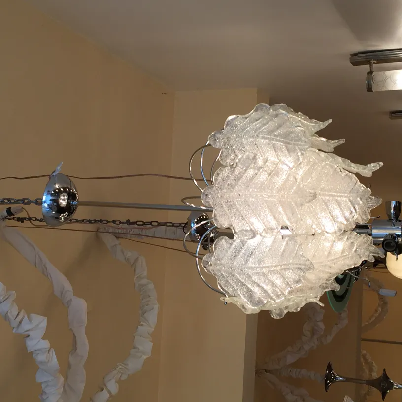 Antica lampada a sospensione decorativa con design in vetro a foglia, creando un'atmosfera elegante e accogliente.