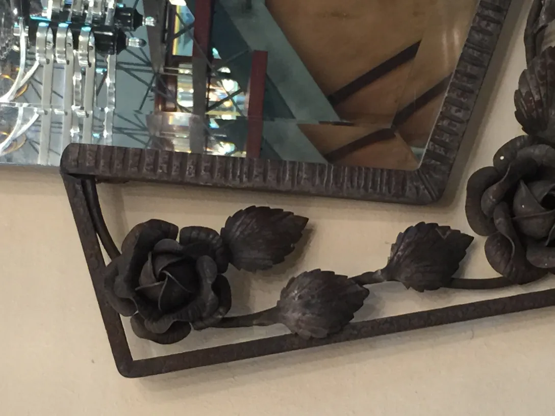 antique mirror with a dark floral decorated frame