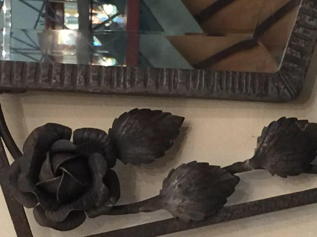 Espelho antigo decorado com uma rosa metálica