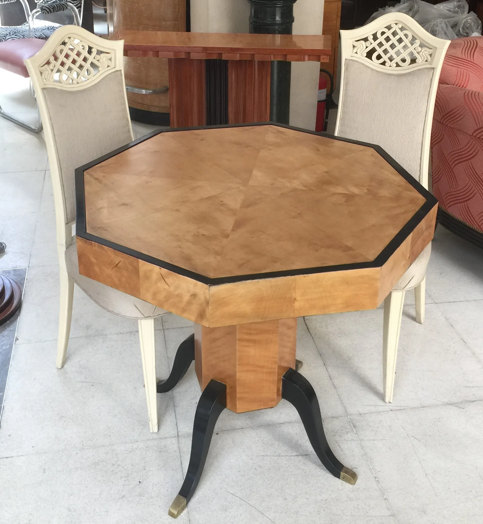 Tavolo ottagonale per 4 persone, stile Art Deco, con sedie bianche, atmosfera elegante.