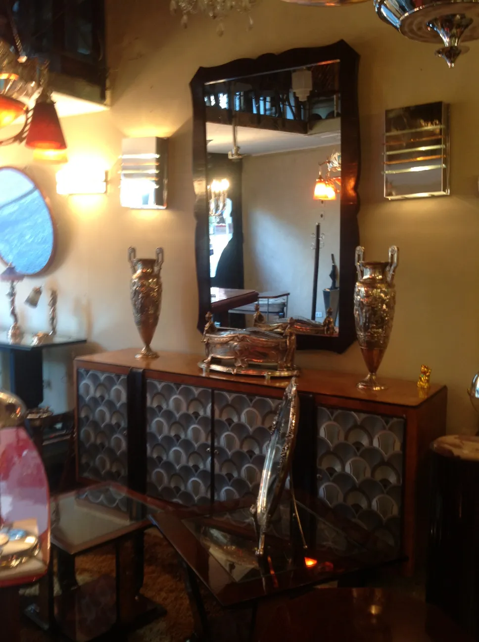 Miroir ancien au-dessus de meubles décoratifs avec des vases.