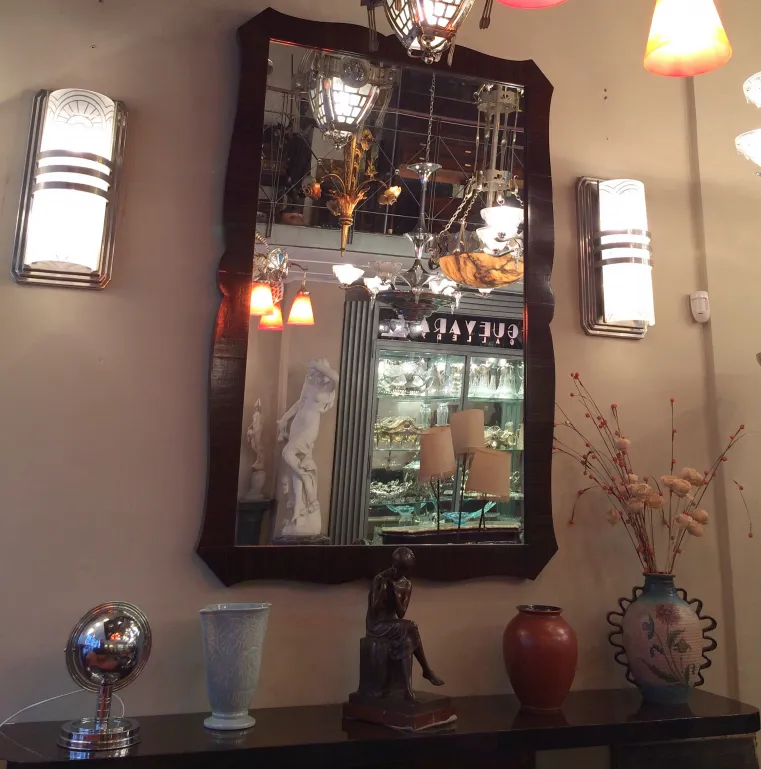 antique mirror with decorative frame in an elegant setting with lights