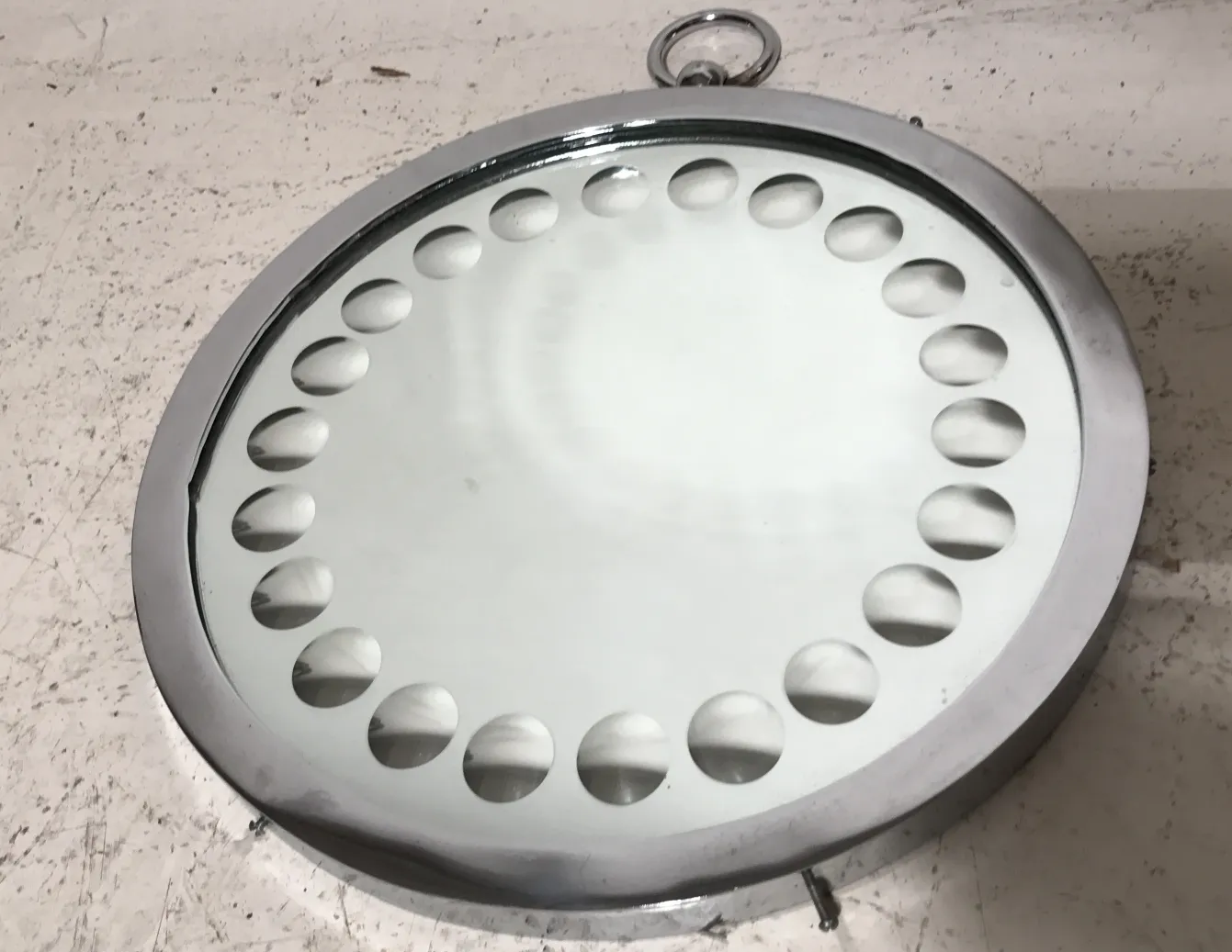 Espejo antiguo con detalles redondeados en el marco, en fondo neutro