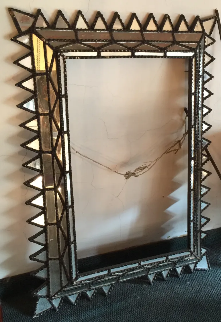 Antique mirror with decorative triangular frame.