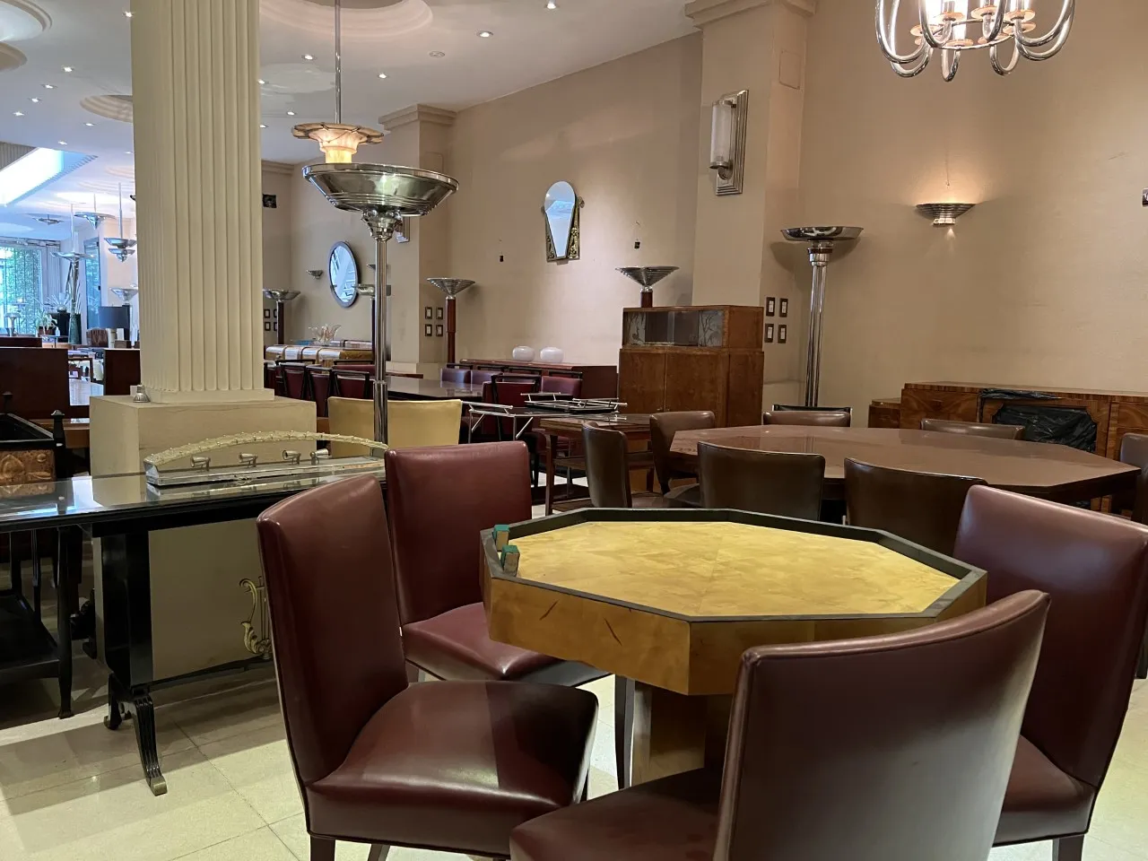 Mesa octogonal antiga de estilo Art Deco com cadeiras em um ambiente elegante.