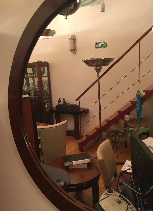 Espelho antigo decorativo refletindo um ambiente acolhedor.