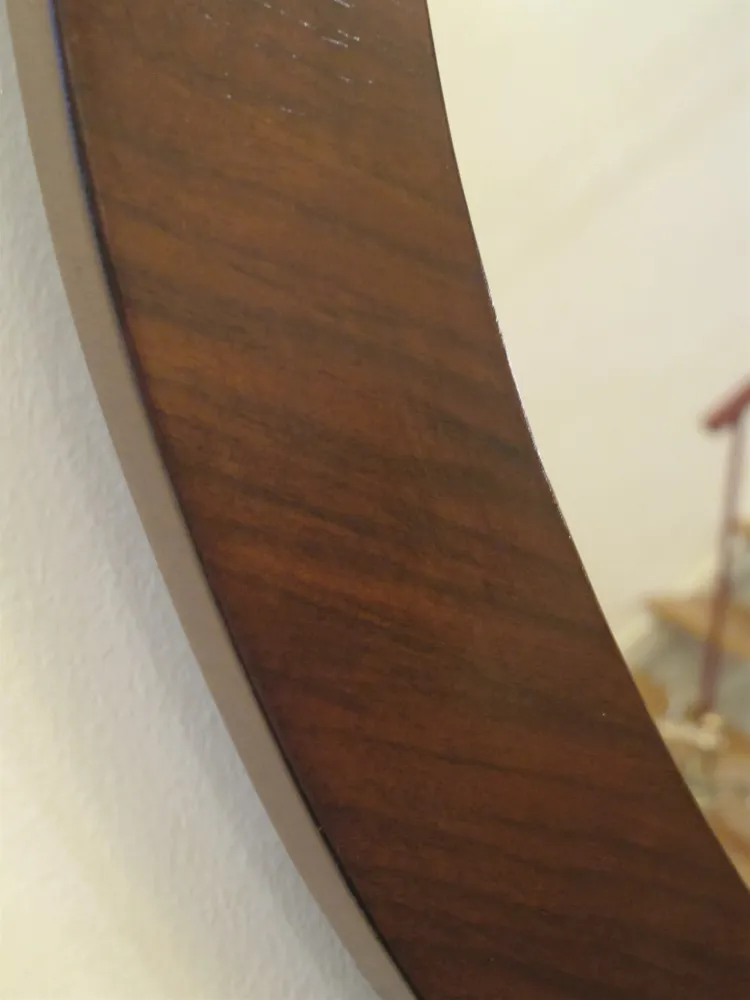 miroir ancien avec cadre décoratif sur un mur clair