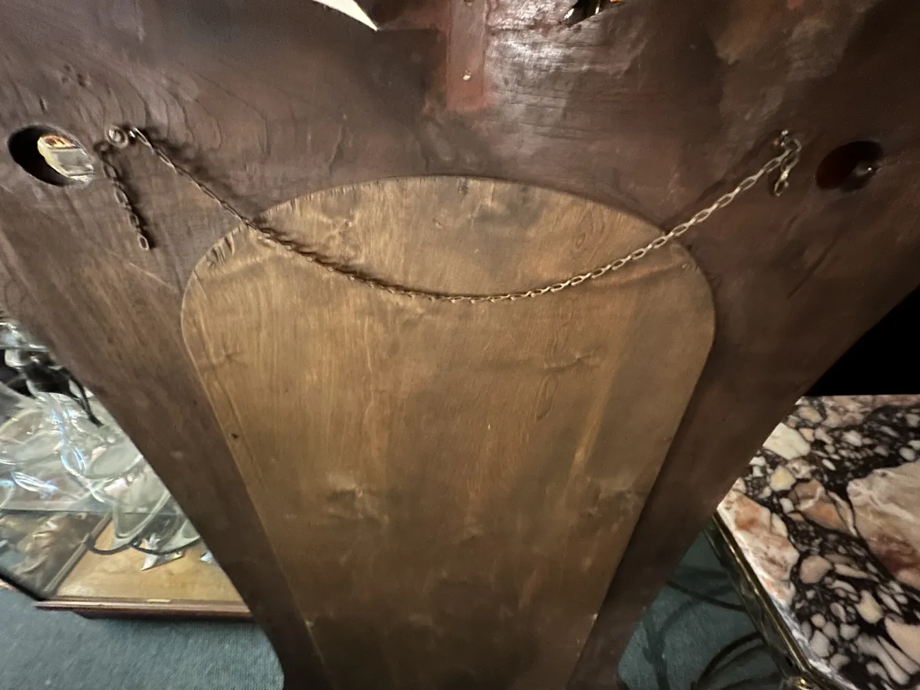 espejo antiguo con cadena, fondo oscuro y madera