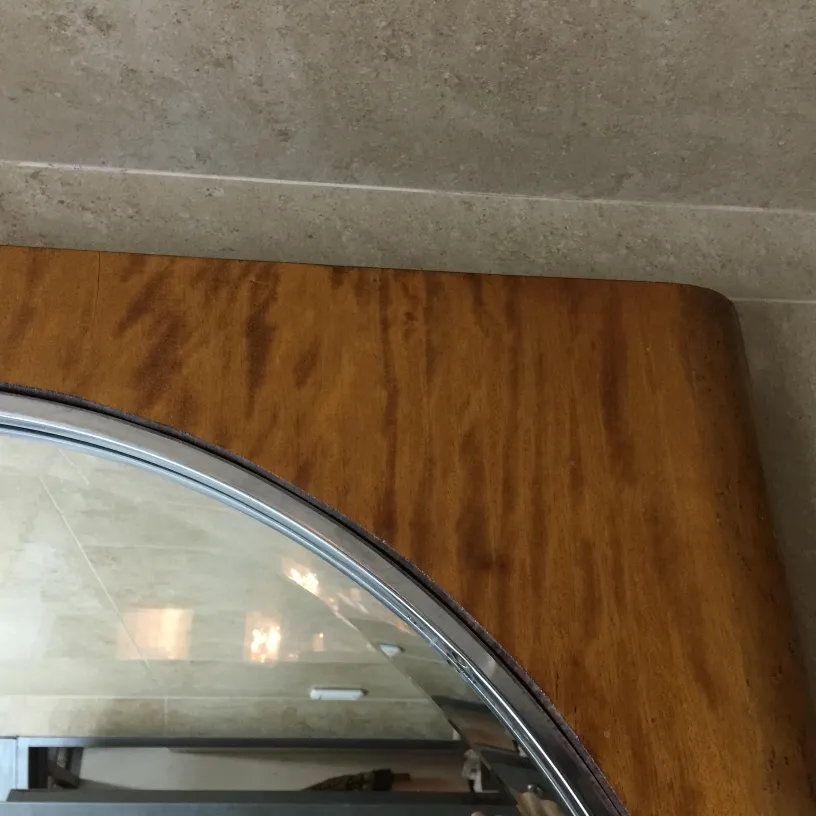 Miroir ancien avec cadre arrondi dans un cadre élégant.