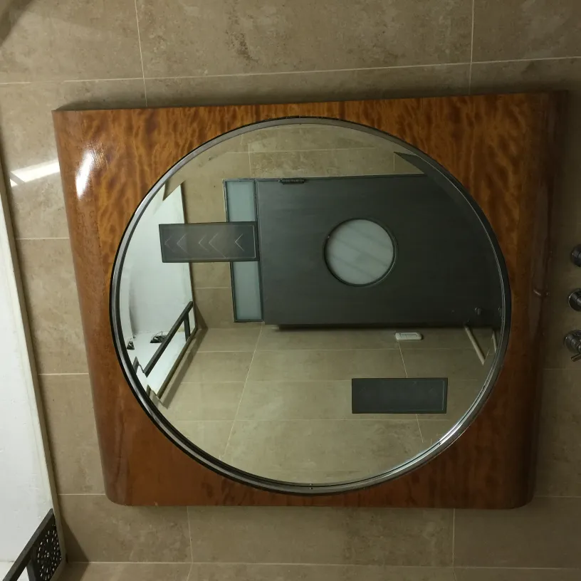 Antique mirror with classic frame and circular surface.