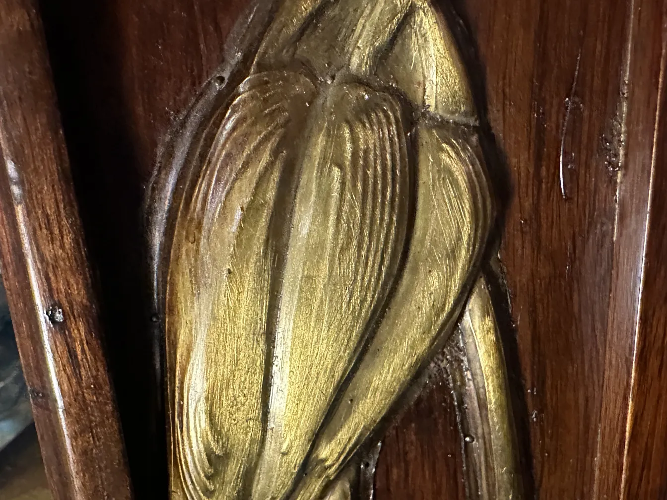 Espelho antigo decorado com detalhes dourados em um ambiente clássico.