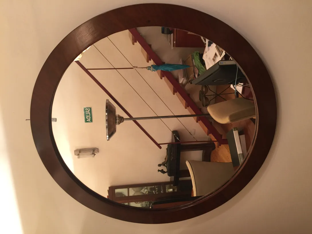 antique round mirror with decorative frame in classic setting