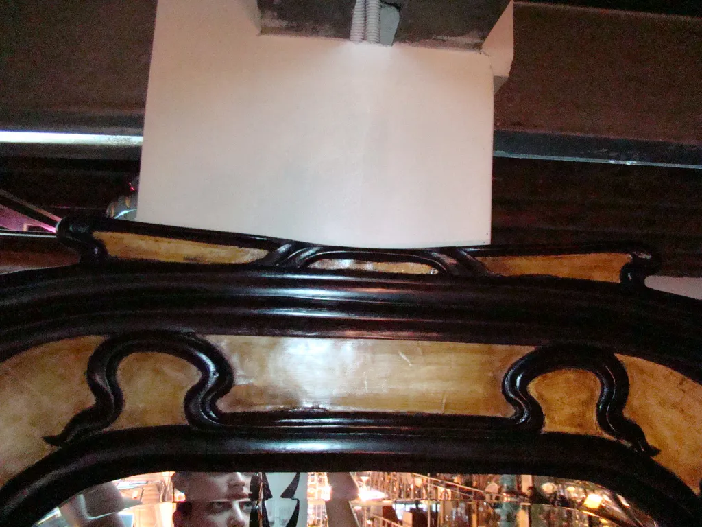 specchio antico con cornice elaborata in stile art nouveau.