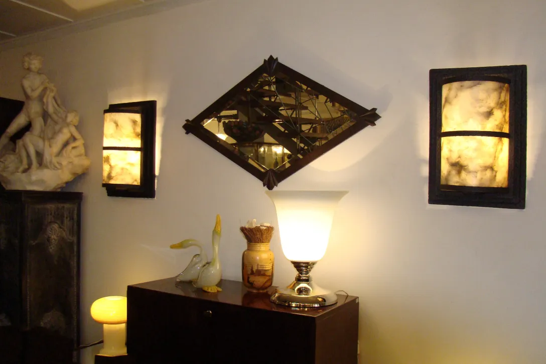 antiker dekorativer Spiegel mit elegantem Rahmen, beleuchtet von Lampen