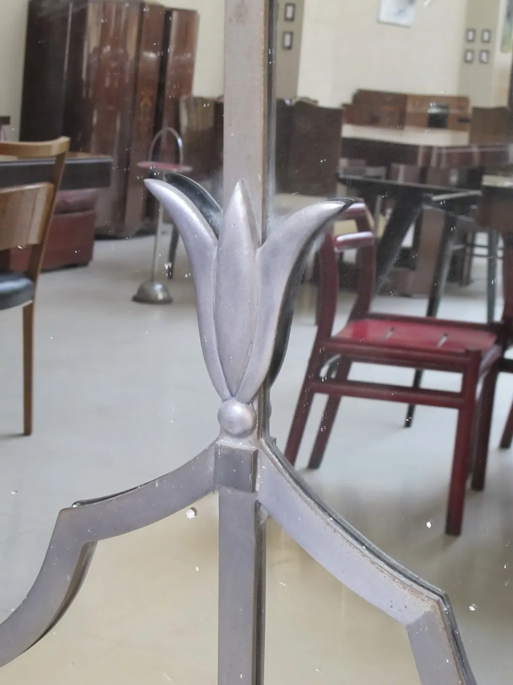 specchio antico con dettagli decorativi in alto, ambiente classico sullo sfondo