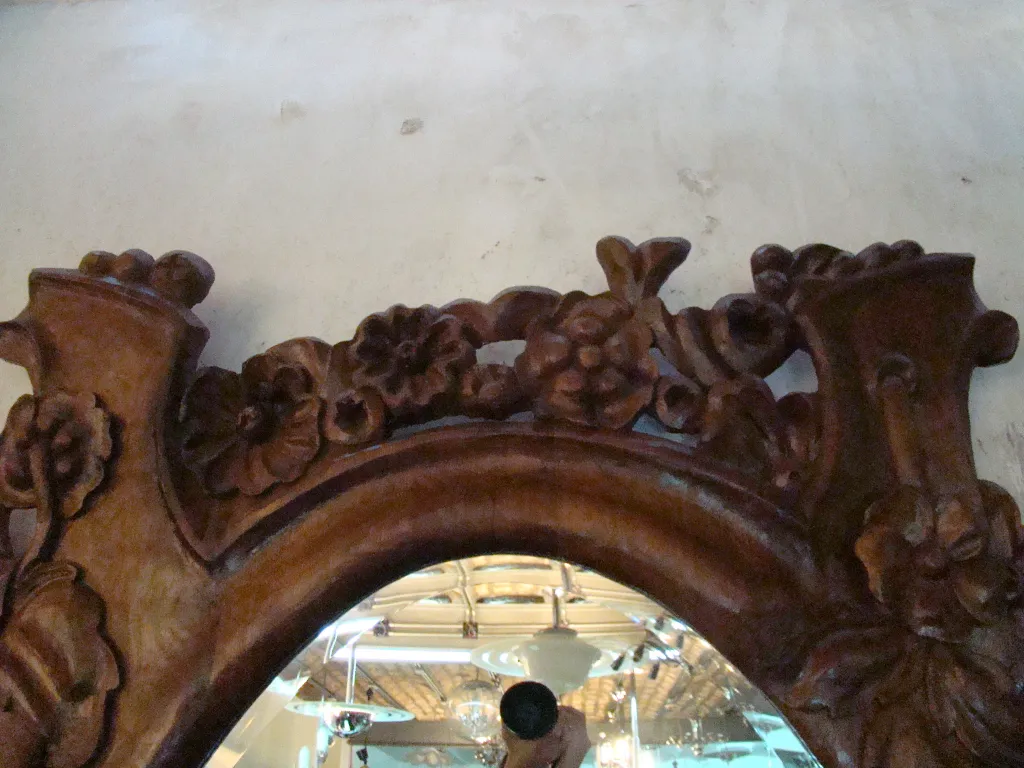 Miroir ancien avec un cadre décoré de fleurs.