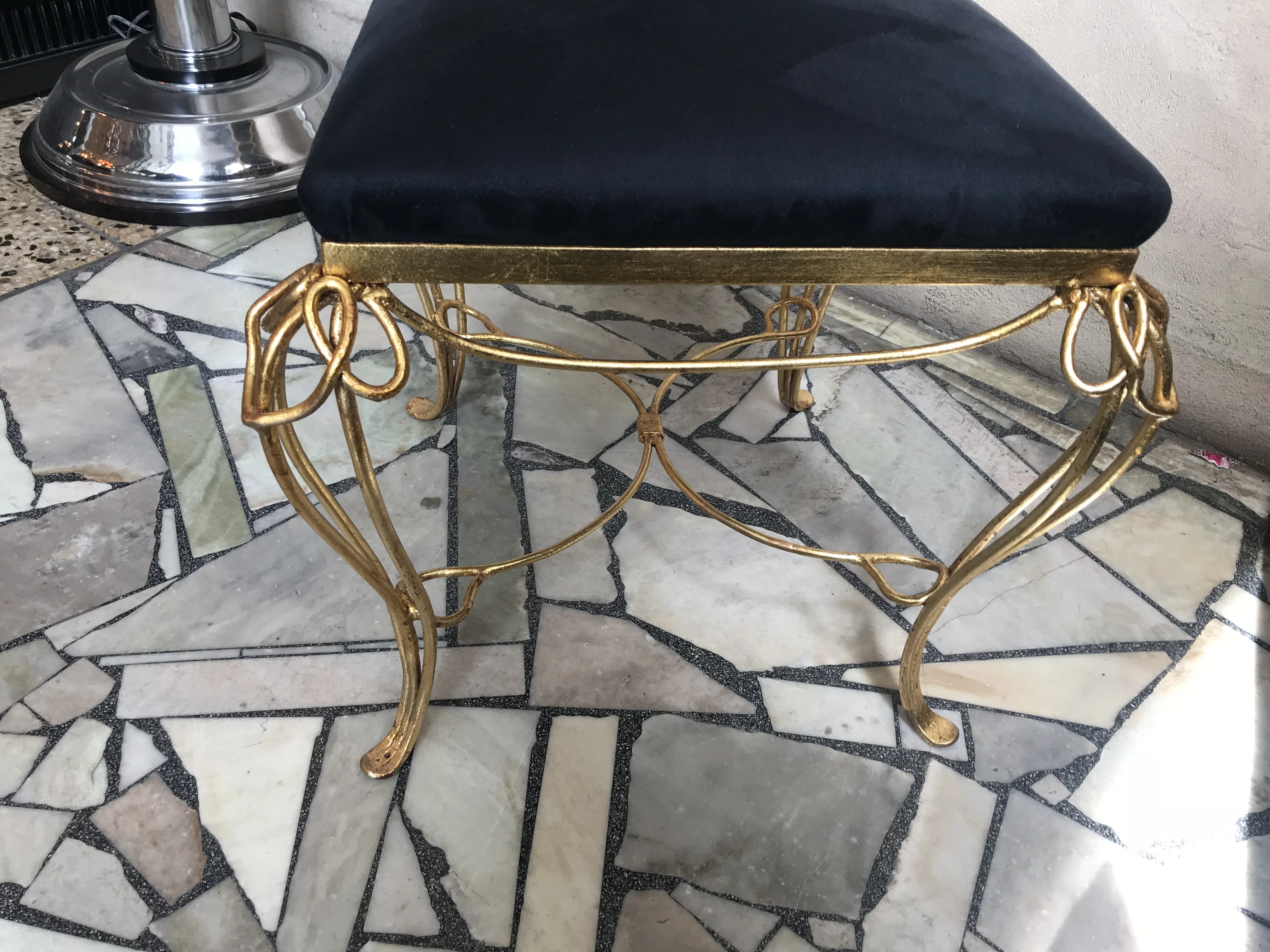 Mesa de jantar antiga com pernas douradas e assento preto