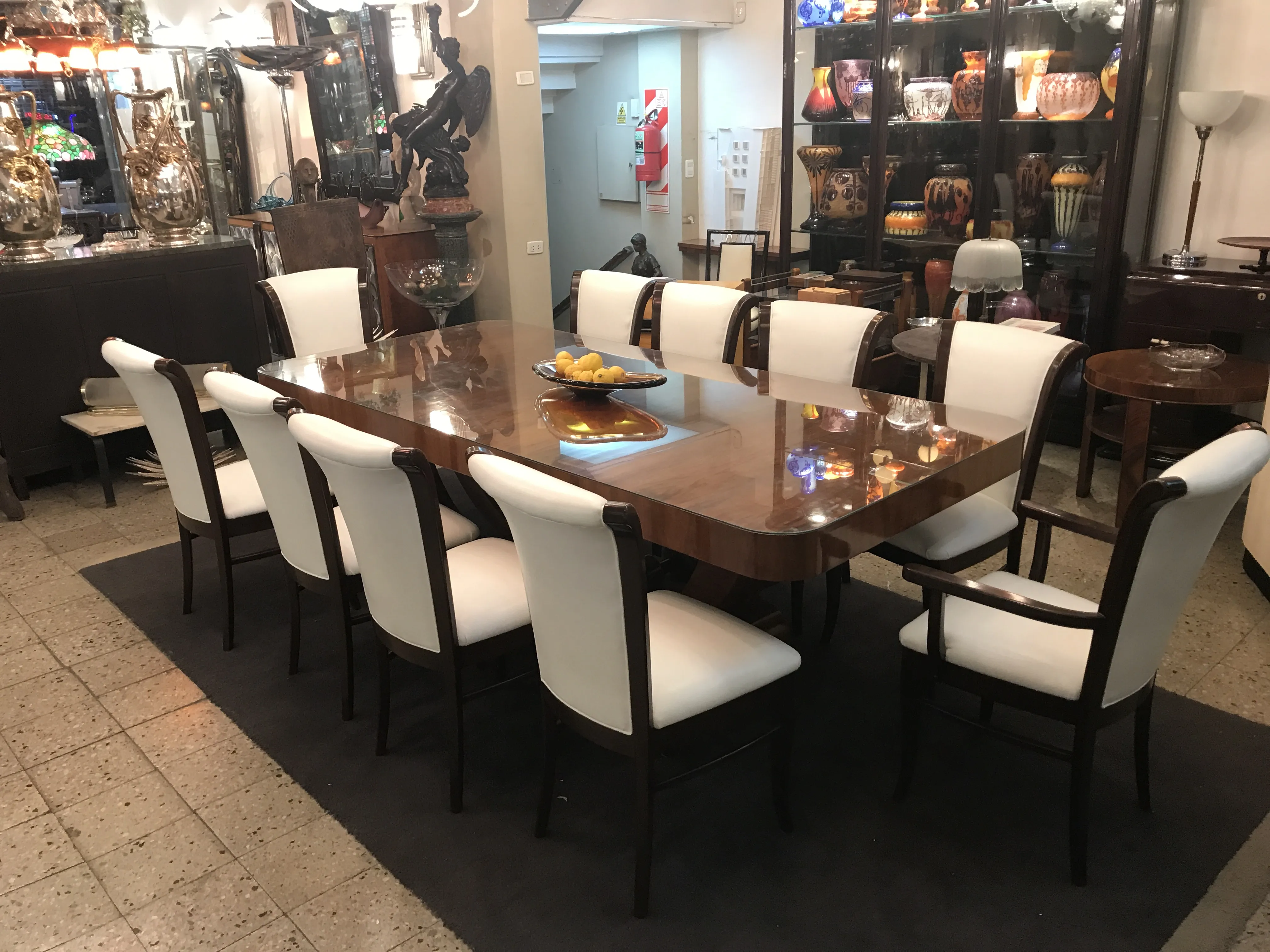 Mesa de comedor antigua Art Deco para 10 personas con sillas elegantes en un ambiente decorativo.
