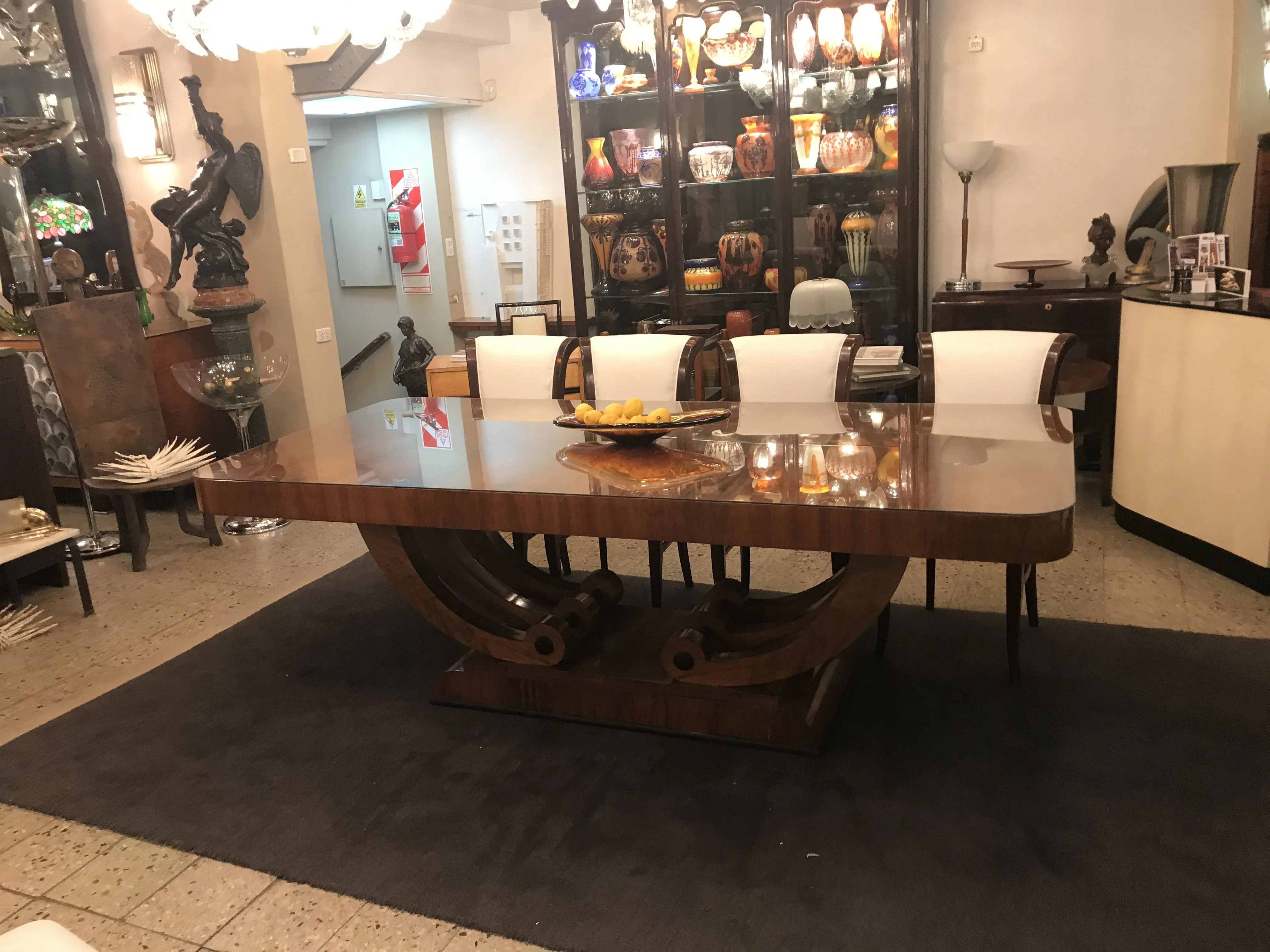 Mesa de jantar antiga Art Deco para 10 pessoas em um ambiente elegante, decorada com frutas e velas.