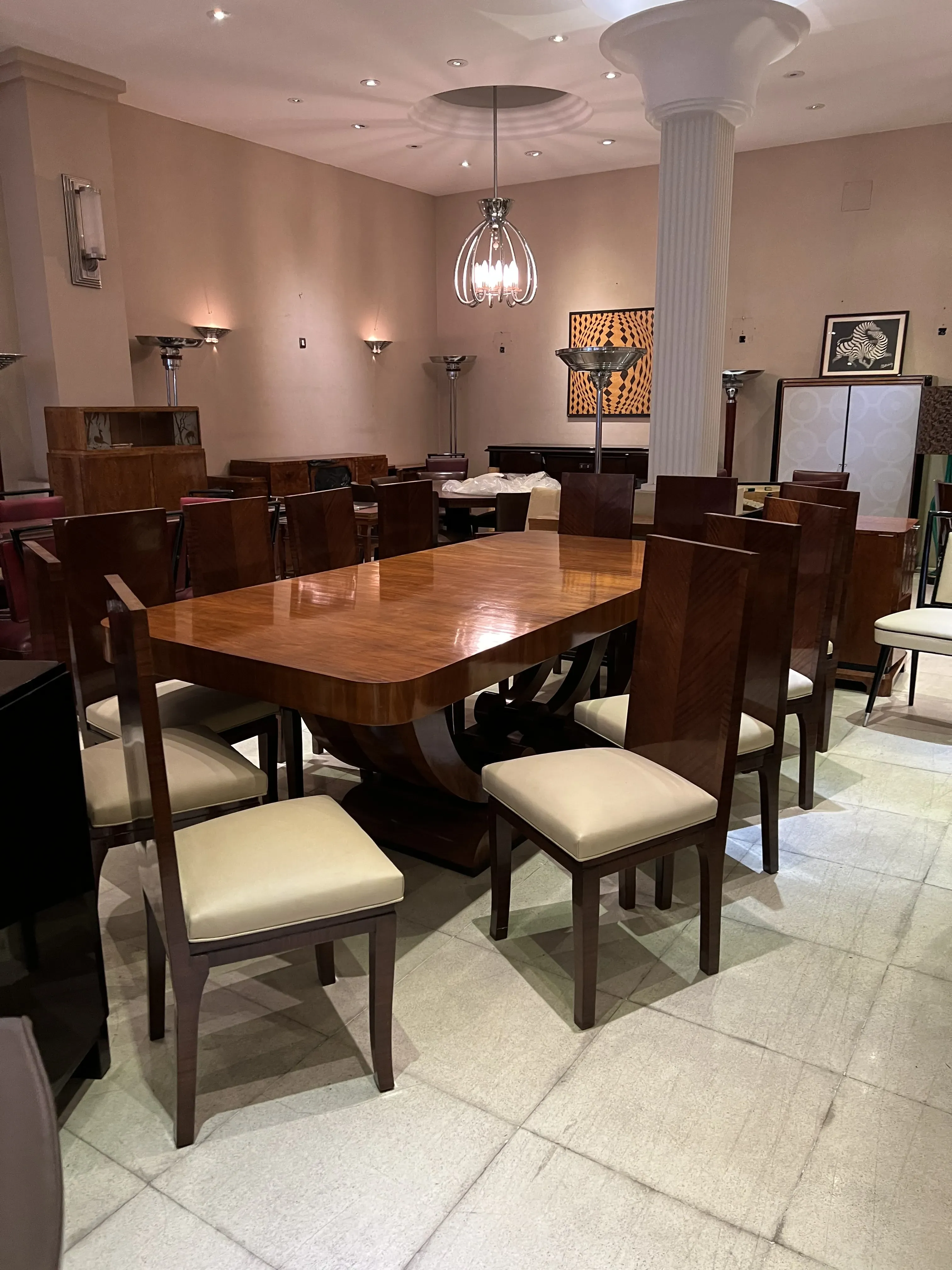 Antique Art Deco dining table for 10 people, surrounded by chairs. Elegant and cozy atmosphere.