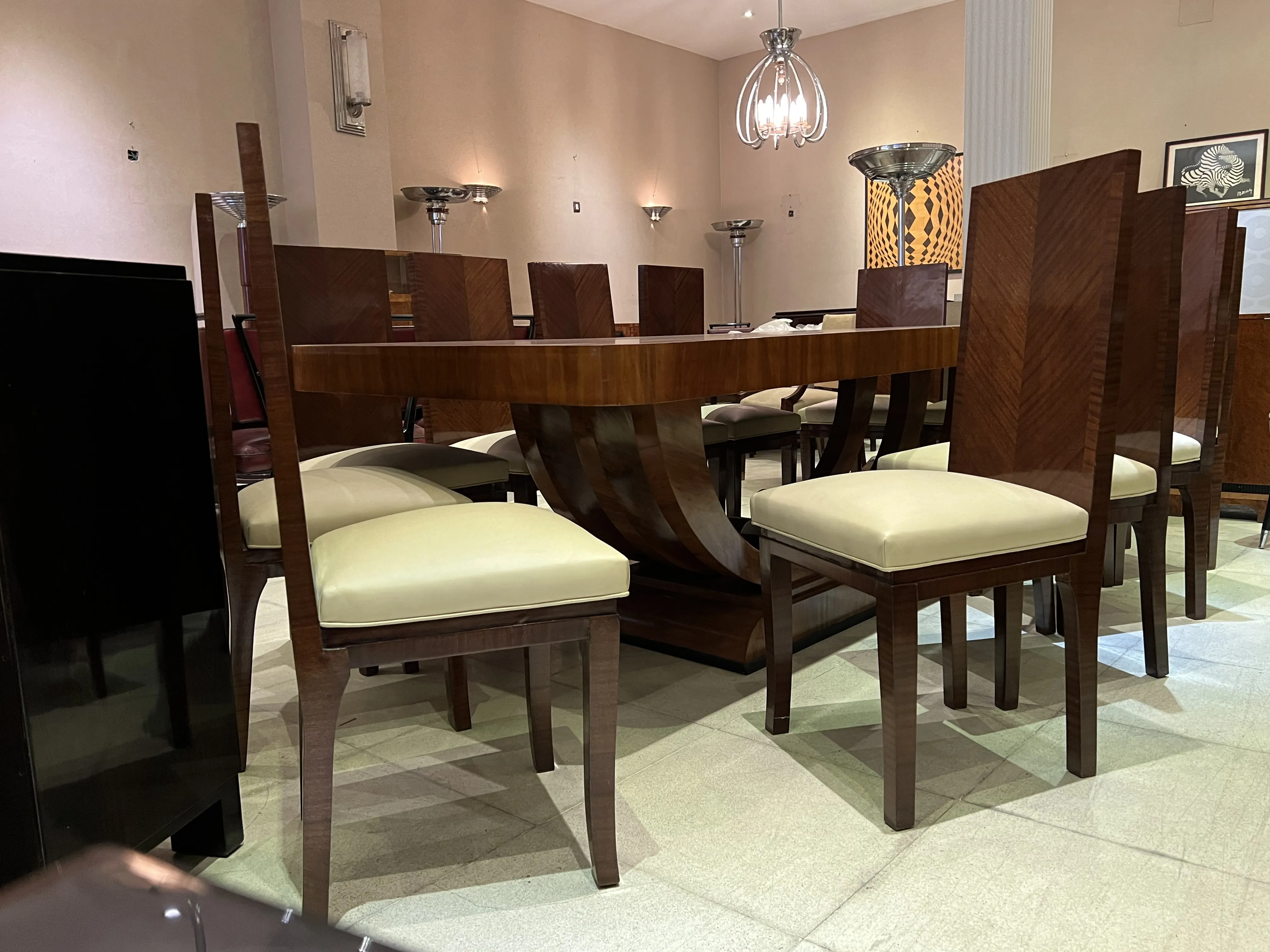 Antiker Esstisch im Art Deco-Stil, für 10 Personen, umgeben von bequemen Stühlen in einem eleganten Ambiente.