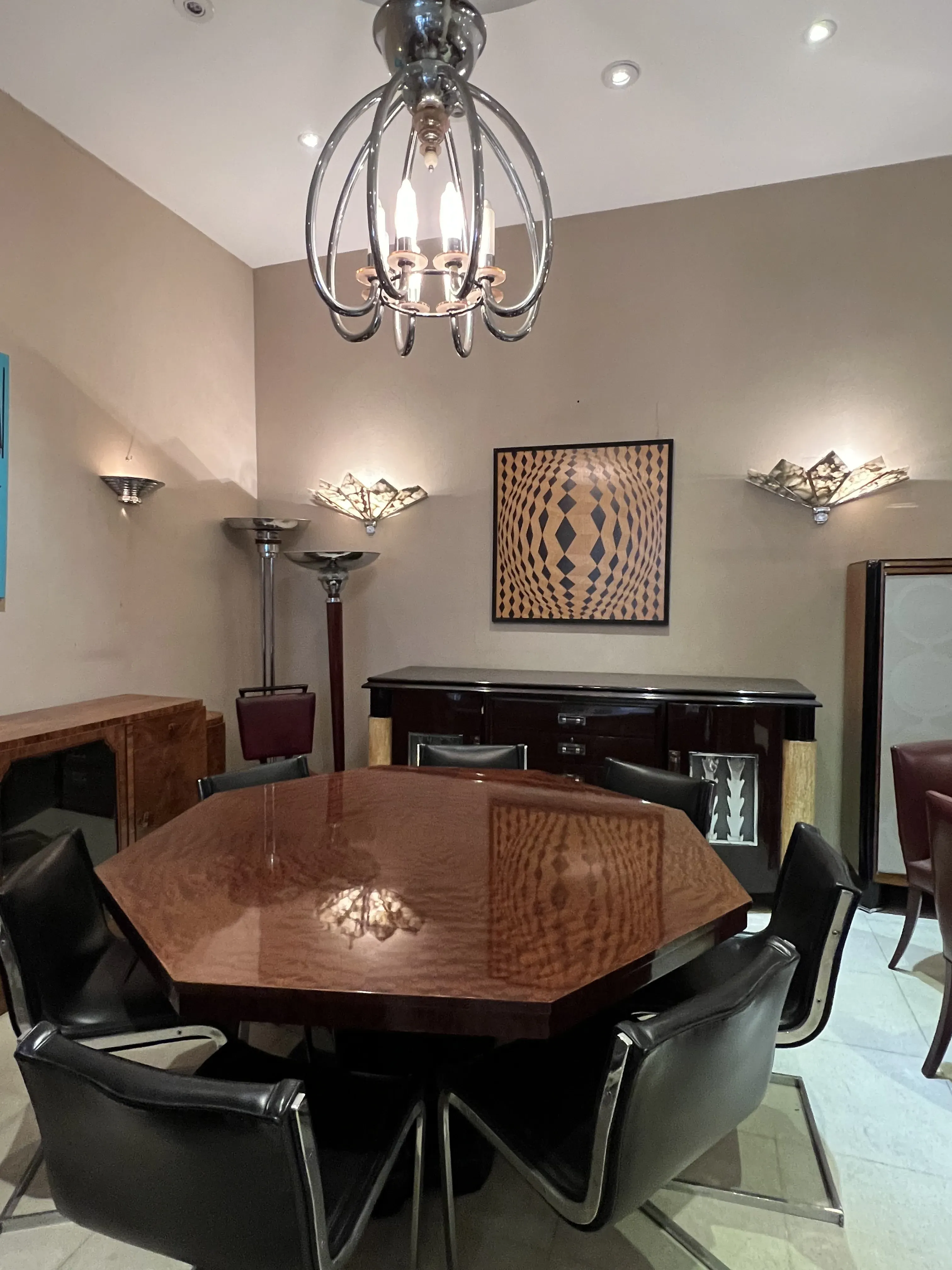 Antique octagonal dining table for 8 people with modern chairs in an elegant setting.