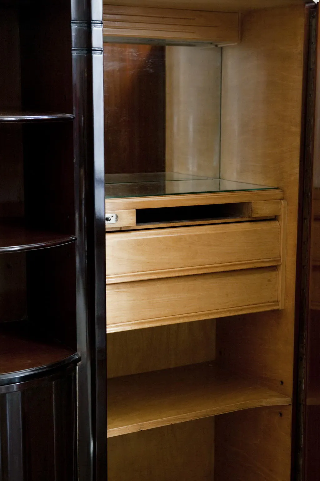 Antikes Bücherregal mit Regalen und einer Schublade, dunkler Hintergrund.