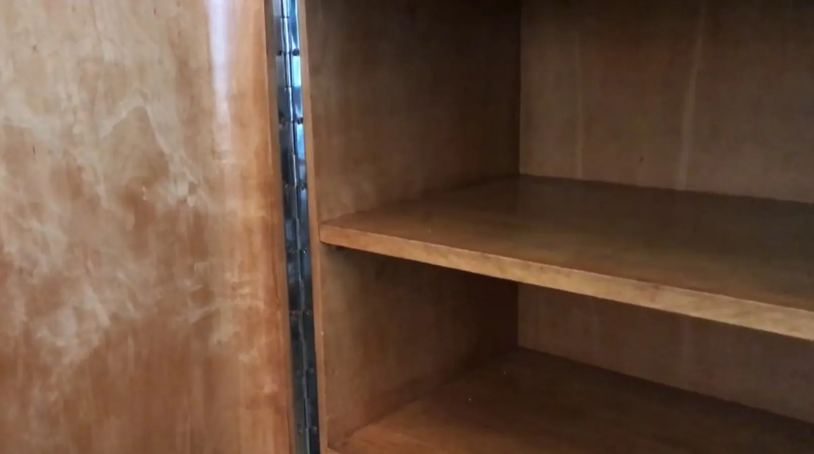 Antique bookcase with empty shelves in a simple setting.