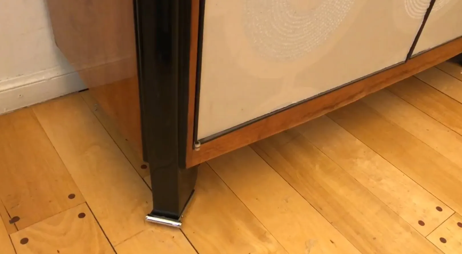 Detalhe de um estante de livros antigo com prateleiras vazias e pé elegante