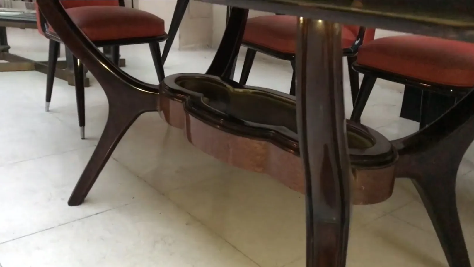 Antique dining table for eight people, elegant design, surrounded by chairs.