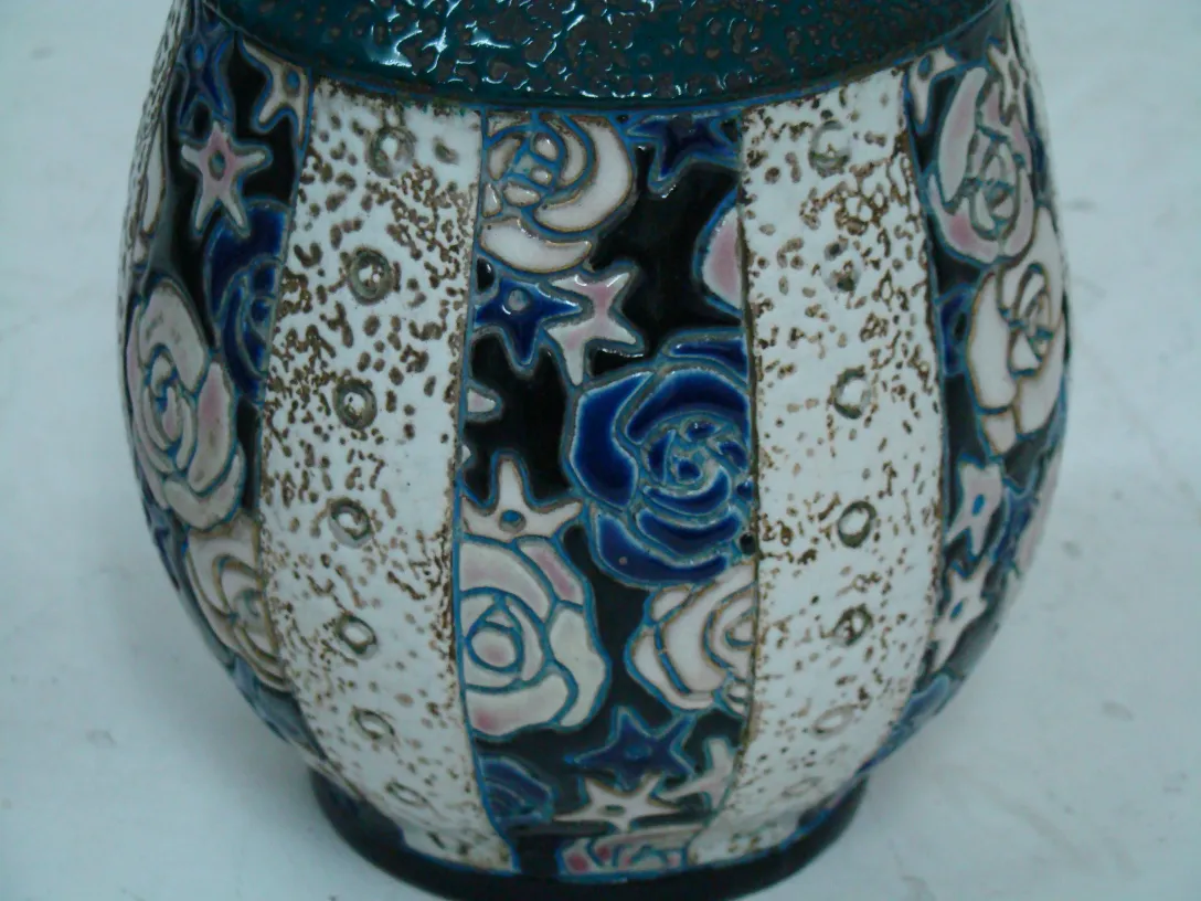 Vaso antigo de cerâmica decorativa com padrões de rosa e estrela. Cores variadas.