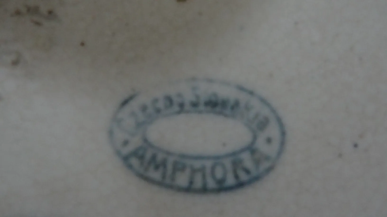 cerâmica antiga com um selo azul na parte inferior