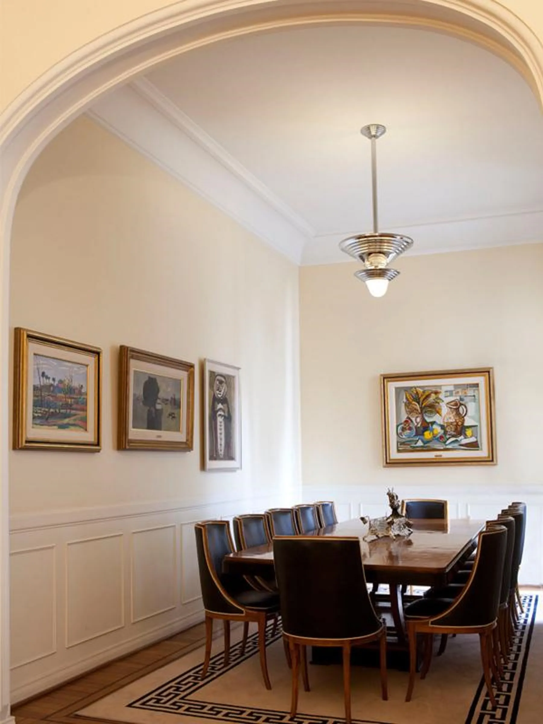 Mesa de jantar antiga com 12 cadeiras em um ambiente elegante.