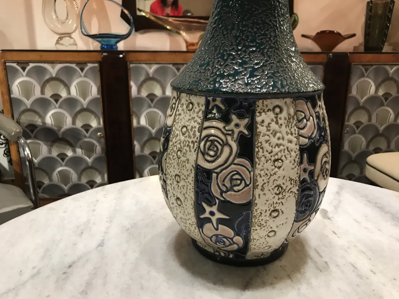 Antike keramische Amphore mit floralen Motiven in einer dekorativen Umgebung.