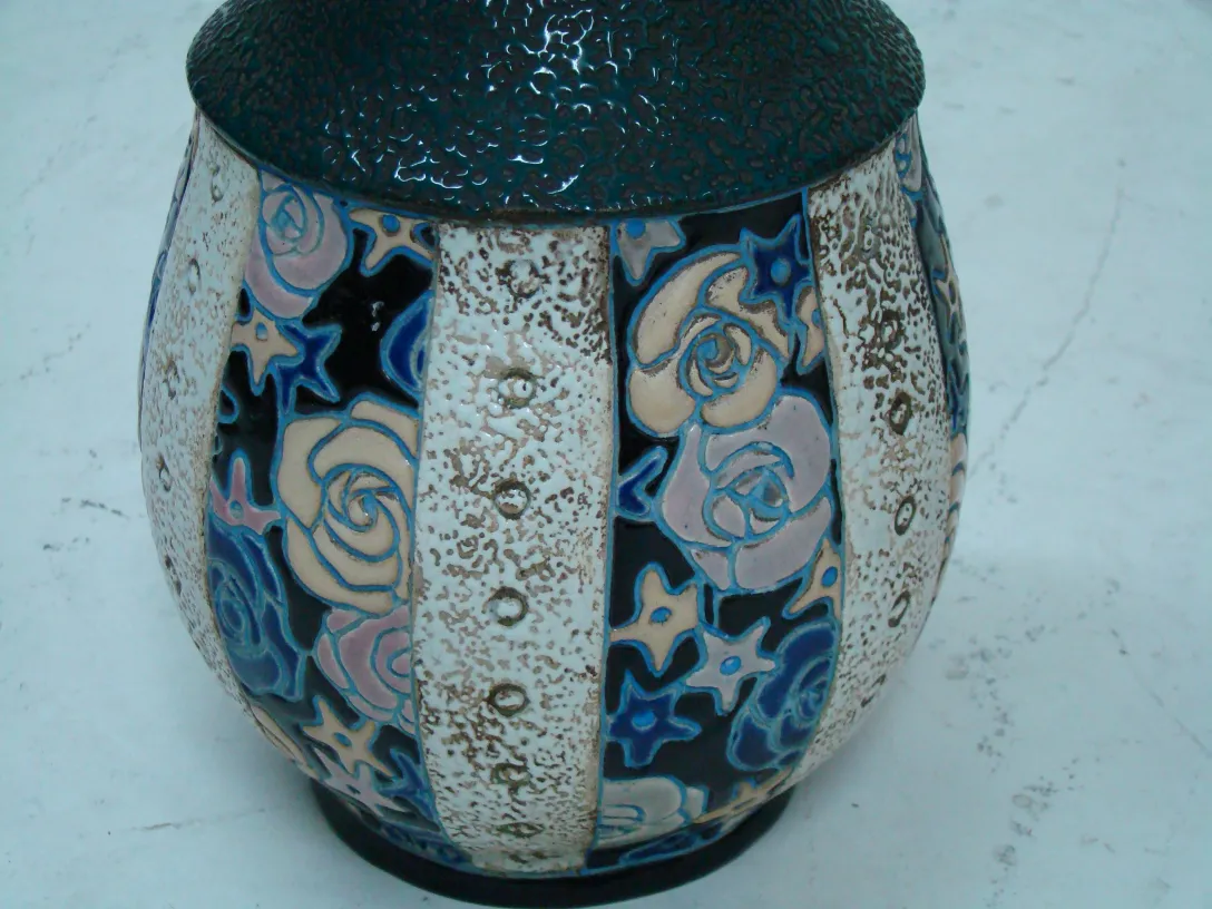 Antique ceramic vase decorated with roses on a blue background.