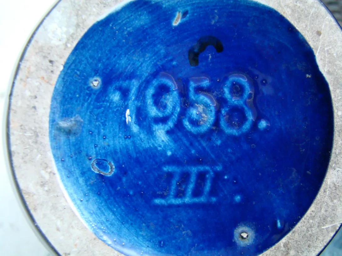 Piatto di ceramica antica con finitura blu brillante e iscrizioni.