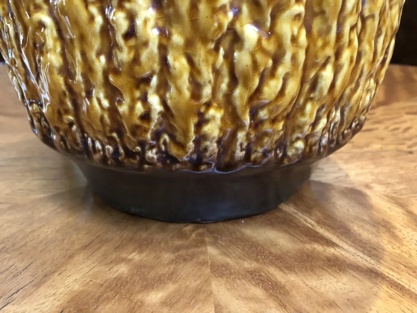 فازا سيراميك قديم بلون كهرمان يتكون من سطح غير منتظم على طاولة خشبية.