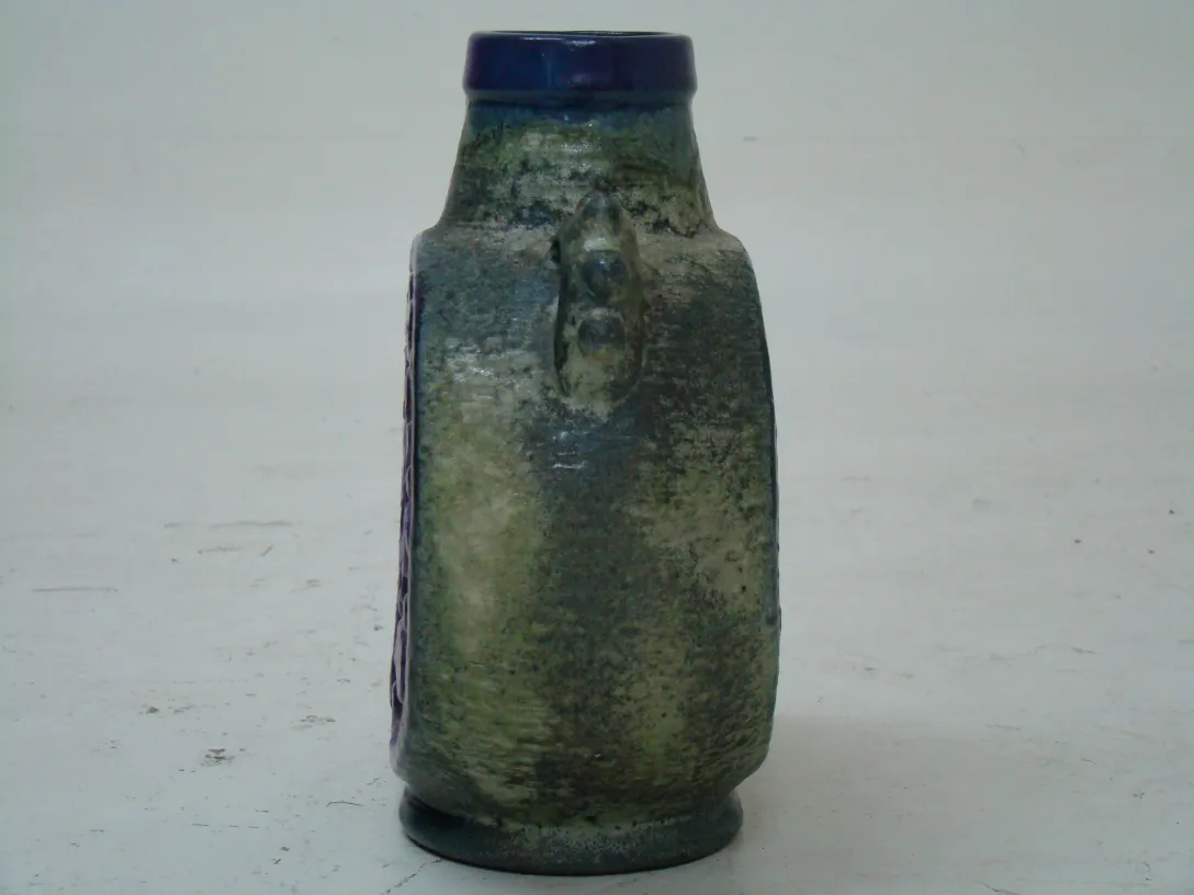 botella de cerámica antigua con detalles decorativos