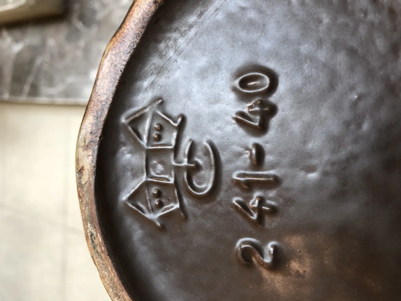 प्राचीन सजावटी मिट्टी के बर्तन जिसमें आधार पर खुदे हुए विवरण हैं।