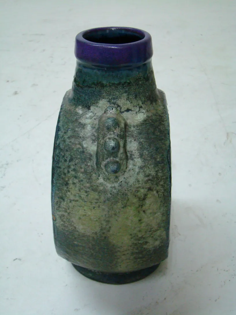Ancienne céramique aux nuances vertes et violettes.