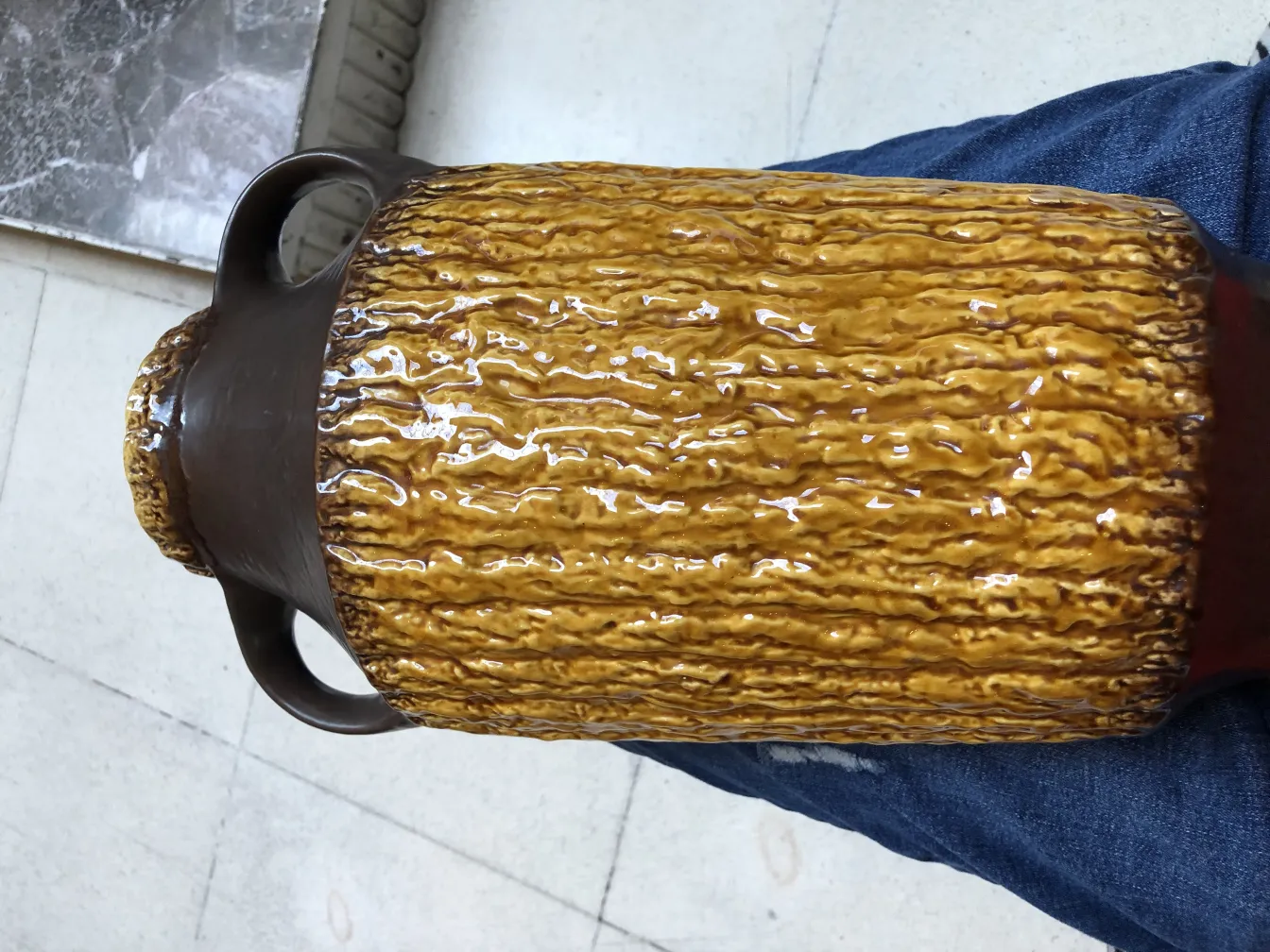 vase en céramique ancienne de couleur marron avec une texture décorative, environnement intérieur