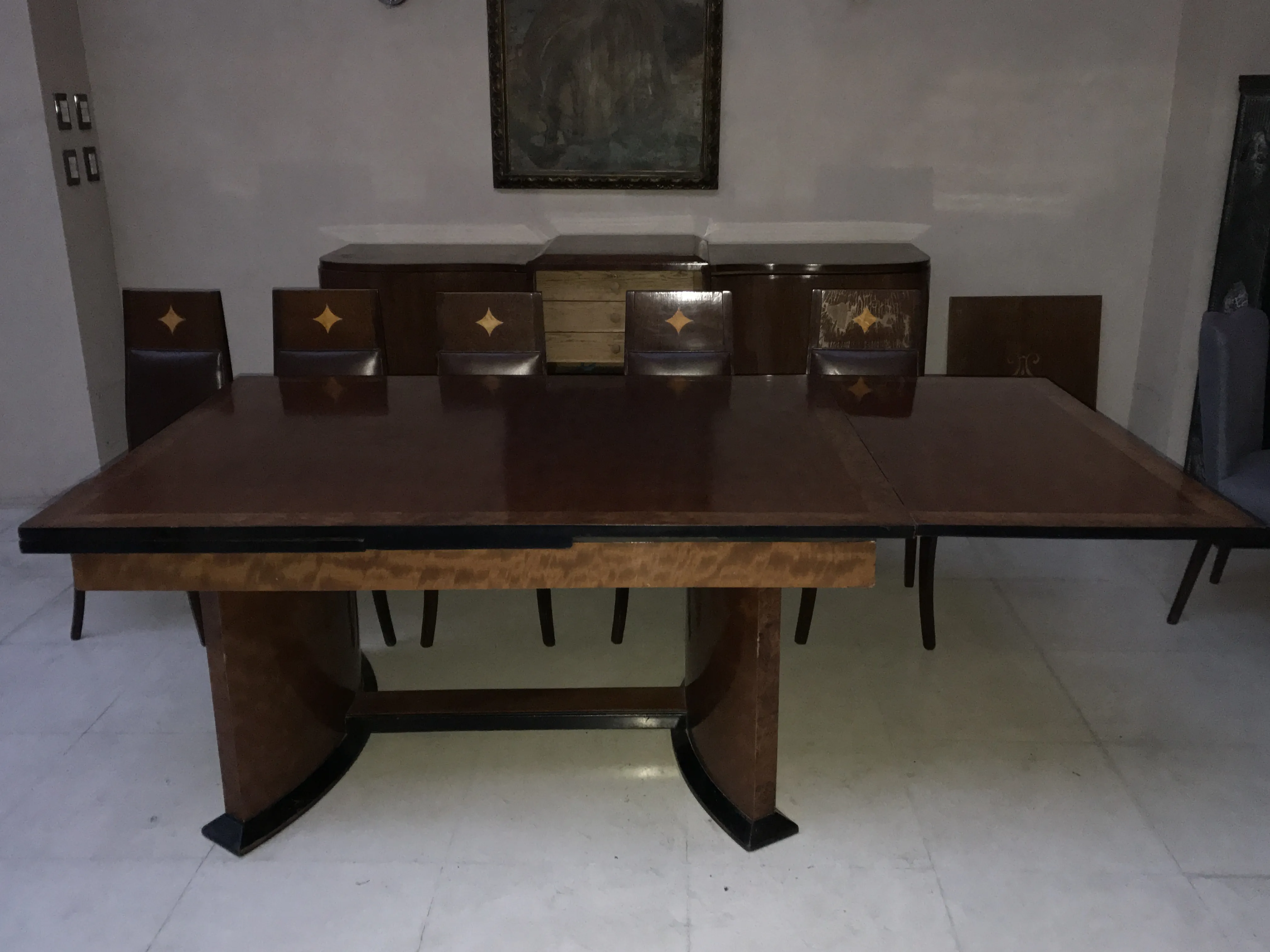 Antique Art Deco dining table for 12 people, surrounded by decorative chairs.