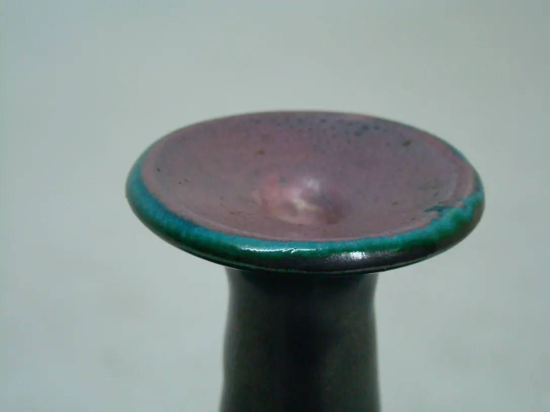 緑と紫の縁のある古代陶器のカップ。