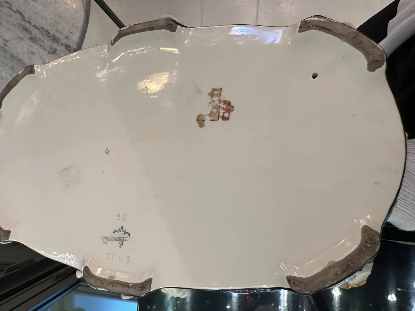 Vista de uma antiga xícara de cerâmica com detalhes decorativos visíveis na parte inferior.