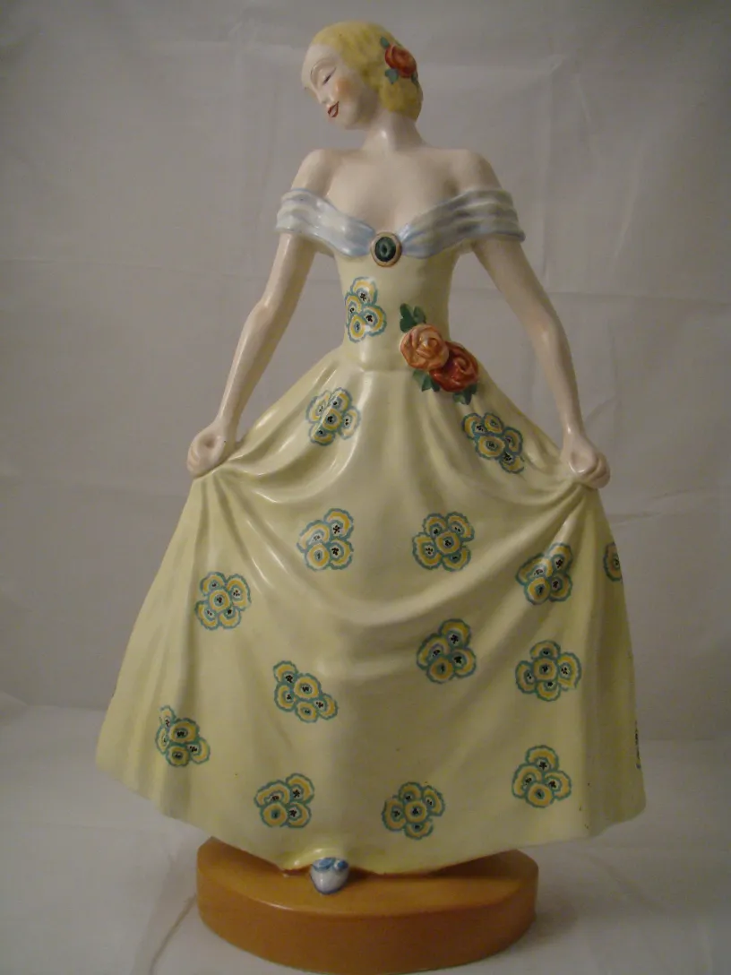 escultura antigua de cerámica con vestido amarillo decorado