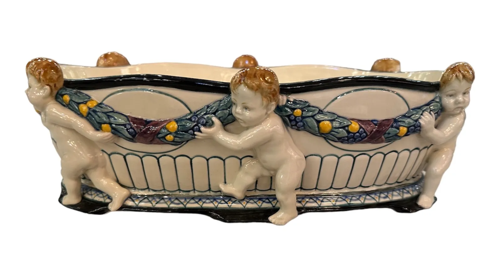 Céramique ancienne décorée de figures d'enfants et de fleurs.