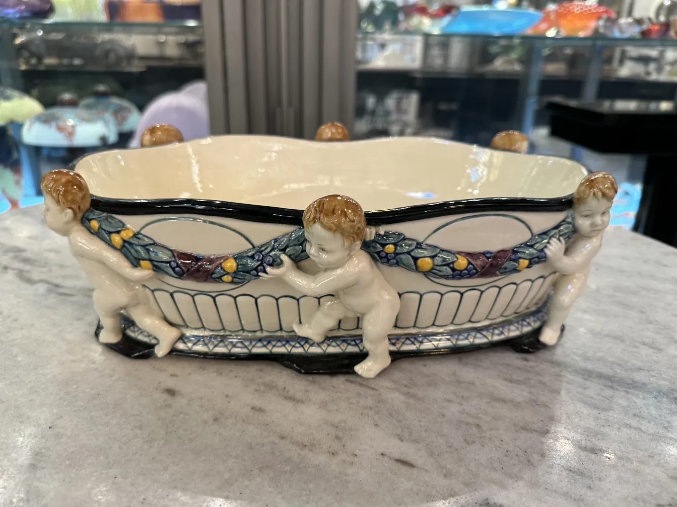 Ceramica antica decorata con cherubini e fiori.